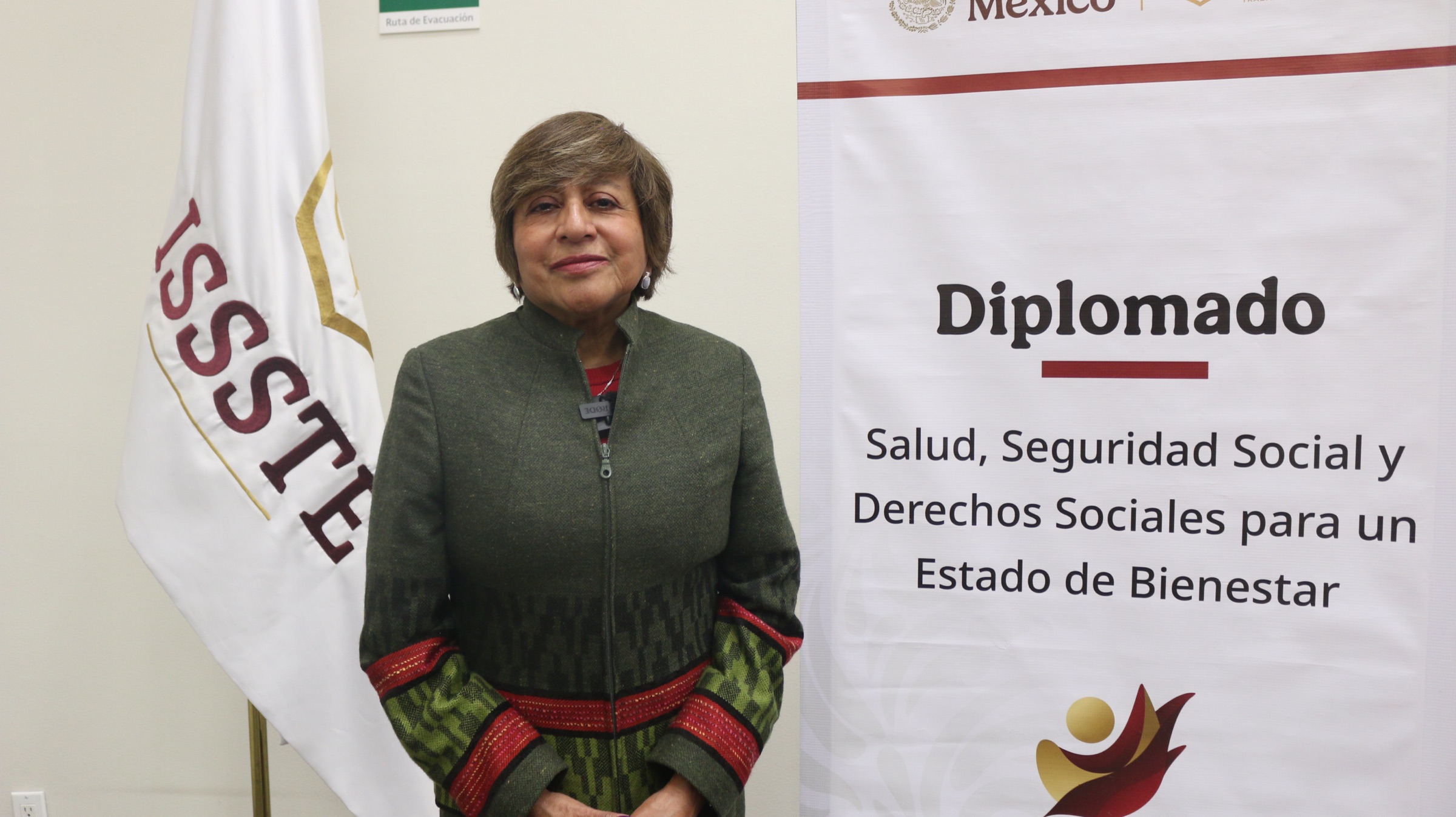 Mtra. Berenice P. Ramírez López junto al banner del Diplomado
